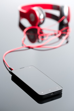 cellphone and headphones on glass tableの写真素材