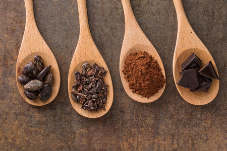 the cocoa and dark chocolate in wooden spoonsの写真素材