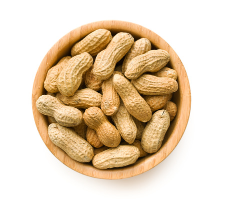 Dried peanuts in wooden bowl isolated on white background.