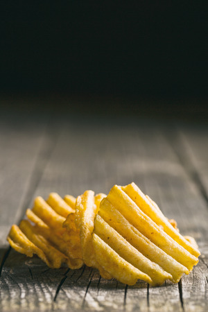 Crinkle cut potato chips on table. Tasty spicy potato chips.の写真素材