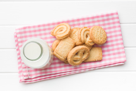 Sweet biscuits and fresh healthy milk on checkered napkin.の写真素材