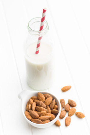 Almond milk and almonds. Tasty milk in glass bottle.の写真素材