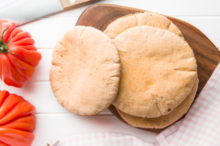 Tasty pita bread on white kitchen table.