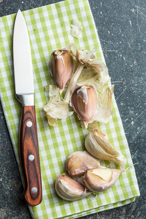 The fresh garlic with knife on kitchen table.の写真素材