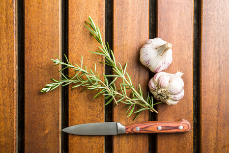 Garlic and rosemary on wooden table.の写真素材