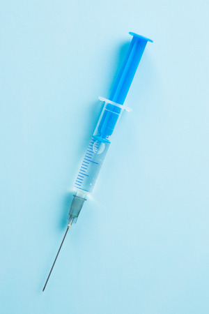 Medical syringe on blue background.の写真素材