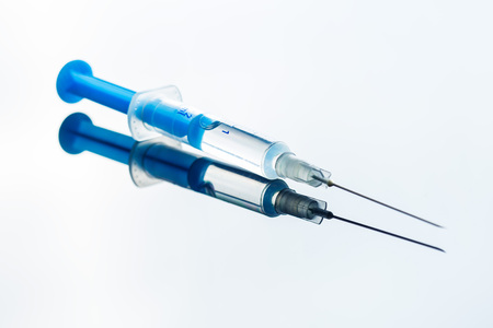 The medical syringe on mirror background.の写真素材