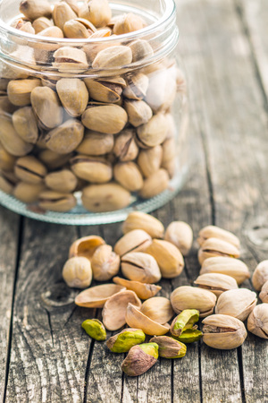 The pistachio nuts on old wooden table.の写真素材