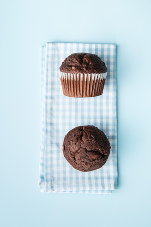 The tasty chocolate muffins on checkered napkin. Top view.の写真素材