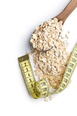 Diet concept. Dry rolled oatmeal and measuring tape.の写真素材