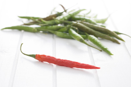 The chili peppers on white table.