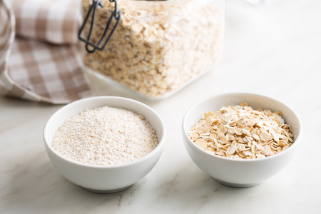 Dry rolled and ground oatmeal in bowls.の写真素材