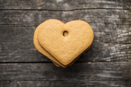Gingerbread shape heart on old wooden table.の写真素材