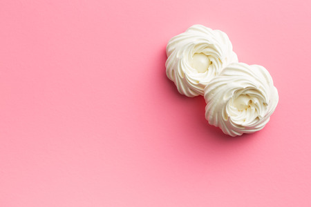 Sweet white meringue on pink background.の写真素材