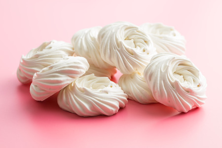 Sweet white meringue on pink background.の写真素材