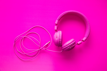 Pink hipster headphones on pink background. Top view.の写真素材