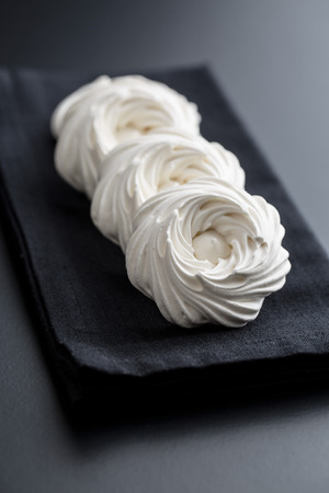 Sweet white meringue on black table.の写真素材