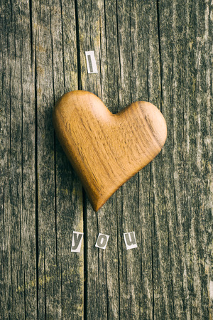 Wooden heart on wooden table. Top view. Inscription I love you.の写真素材