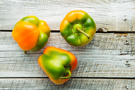 Multicolored bell pepper on old wooden table. Top view.の写真素材