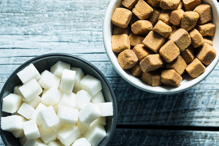 Brown and white sugar cubes in bowl. Top view.の写真素材