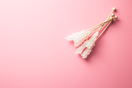 Crystallized sugar on wooden stick on pink background. Top view.の写真素材