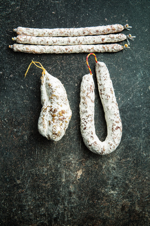 Tasty salami with white mold on kitchen table.の写真素材