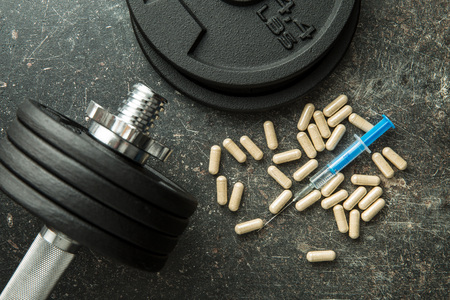Doping in sport. Syringe and dumbbell.の写真素材