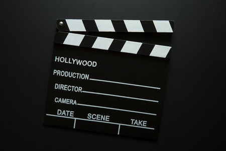 The vintage clapperboard on black background. Top view.