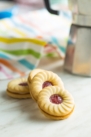 Sweet biscuits with jam on kitchen table.の写真素材