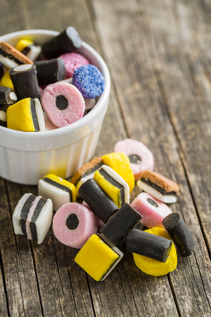 Mixed liquorice candies on old wooden table.の写真素材