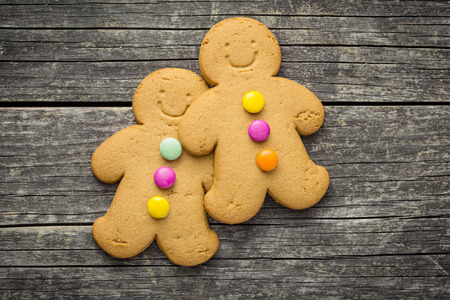 Two sweet gingerbread men on old wooden table. Top view.の写真素材