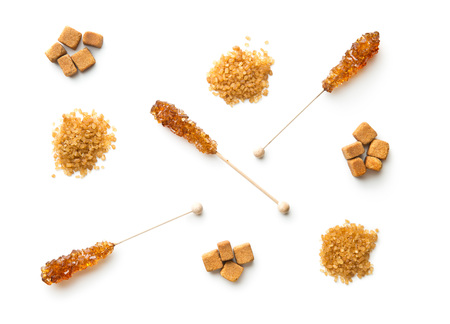 Brown cane sugar, cube sugar and crystalic sugar on wooden sticks isolated on white background. Top view.の写真素材