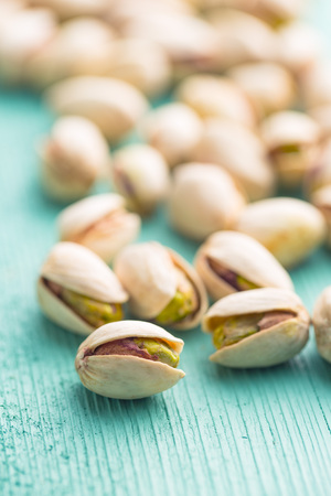 Dried pistachio nuts. On green wooden table.  Pistachio kernel.の写真素材