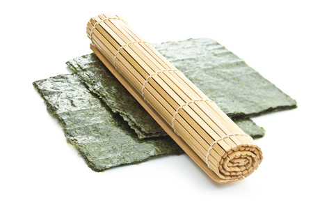 Green nori sheet and bamboo mat isolated on white background.の写真素材