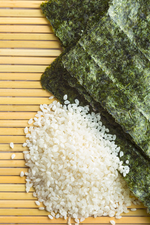 Green nori sheet and sushi rice on bamboo mat. Top view.の写真素材