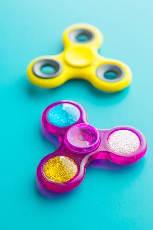 Two fidget finger spinner stress on blue background.の写真素材