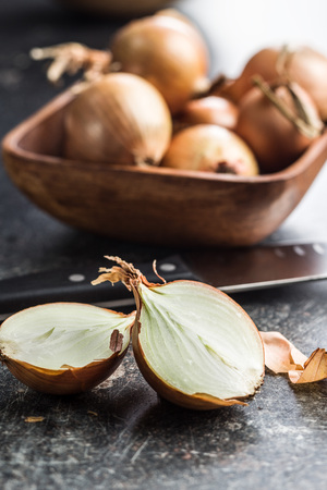 Halved onion bulbs on old kitchen table.の写真素材