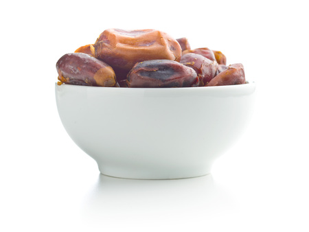 Sweet dates without stones in bowl isolated on white background.