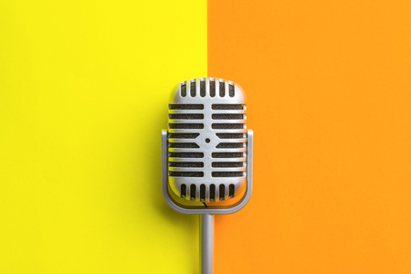 Flat lay of retro microphone on double colorful background.の写真素材
