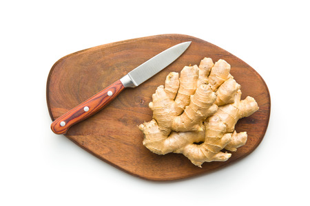 Healthy ginger root on cutting board and knife. Isolated on white background. Flat lay.