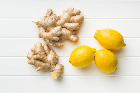 Ginger root and lemons on white table.の写真素材
