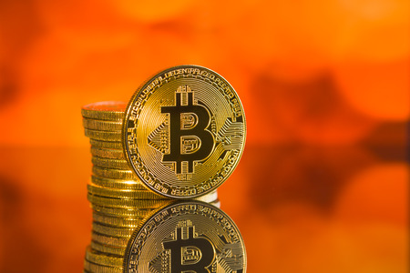 Golden bitcoins. Cryptocurrency in front of colorful background.の写真素材