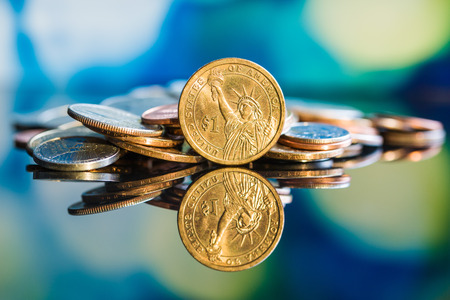 One dollar coin in front of colorful background.の写真素材