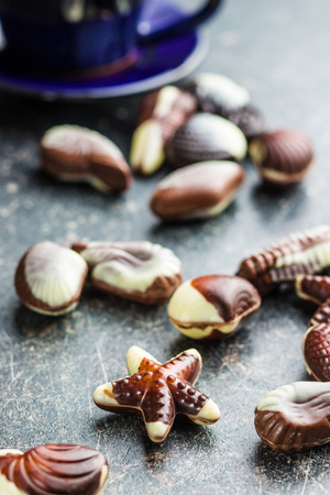 Sweet chocolate seashells on old kitchen table.の写真素材