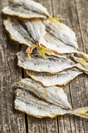 Dried salted fish on old wooden table.の写真素材