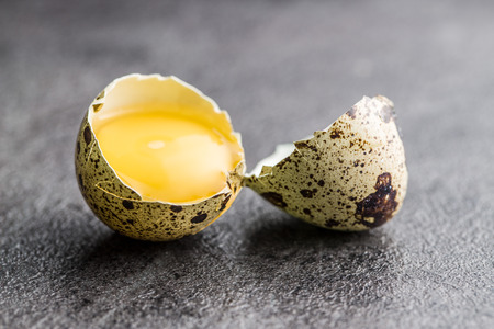 Broken guail eggs on old kitchen table.