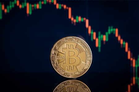 Concept with bitcoins and falling candle graph on background.の写真素材