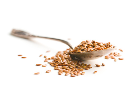 Healthy brown linseeds in spoon isolated on white background.の写真素材