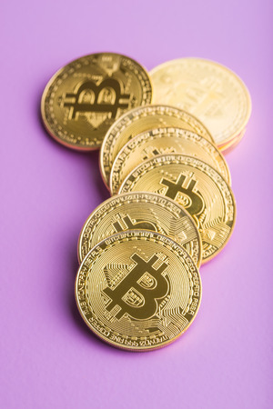 Golden bitcoins. Digital cryptocurrency on violet background.の写真素材