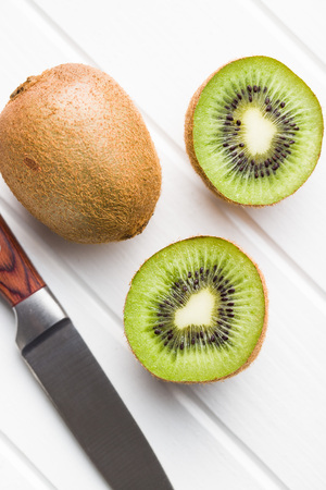Halved kiwi fruit on white table.の写真素材